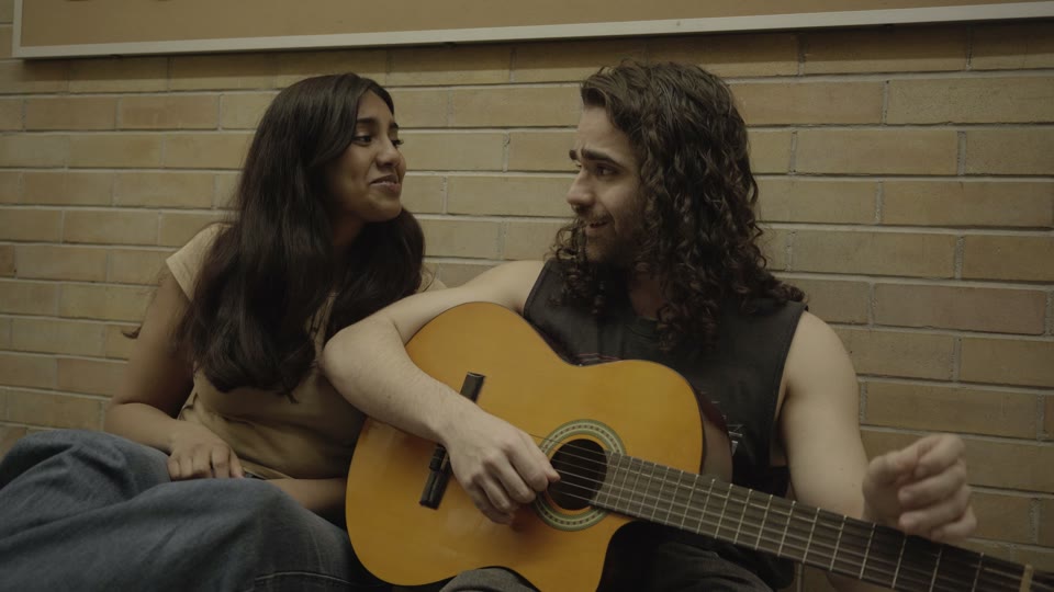 A guitarist and his companion in a scene from The Devil’s Music
