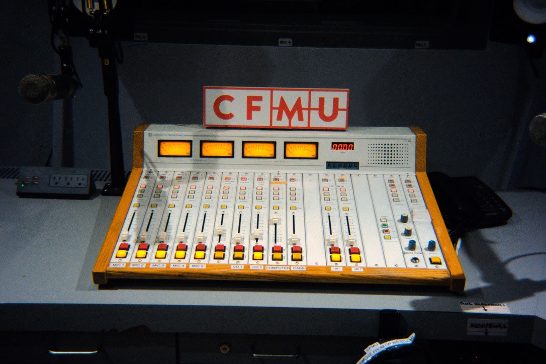 Mixing console, microphones and illuminated meters in the CFMU studio